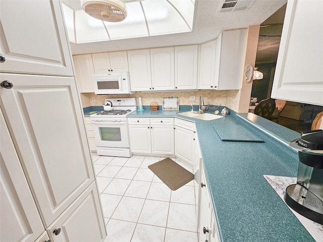 6060 Shore Dr S Unit 906, Gulfport, FL 33707 - kitchen featuring white appliances, a sink, white cabinets, and light tile patterned floors