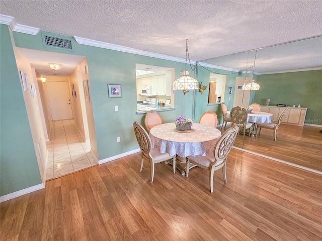 6060 Shore Dr S Unit 906, Gulfport, FL 33707 - dining area featuring ornamental molding, a textured ceiling, wood finished floors, and baseboards