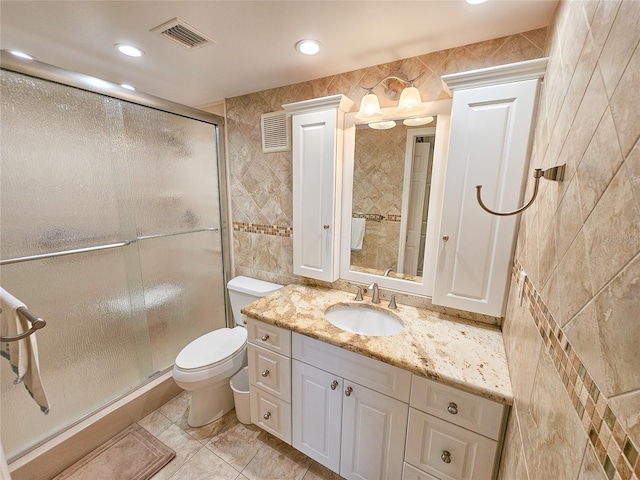6060 Shore Dr S Unit 906, Gulfport, FL 33707 - bathroom featuring tile walls, vanity, toilet, a stall shower, and recessed lighting