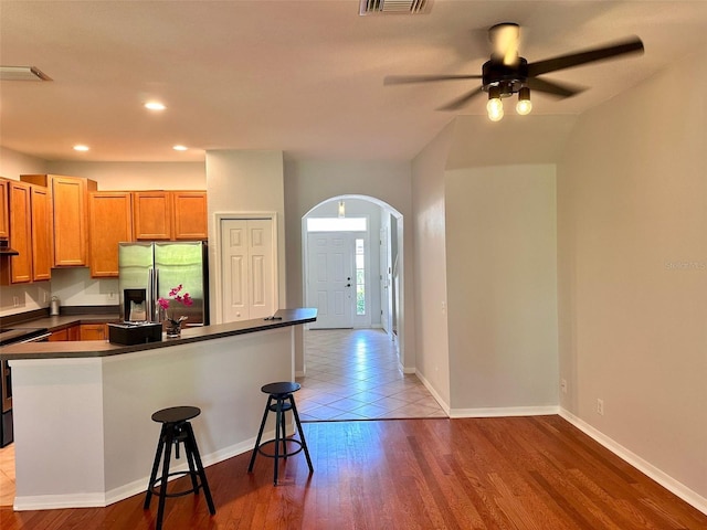 608 Black Lion Dr NE, Saint Petersburg, FL 33716 - kitchen featuring stainless steel appliances, dark countertops, ceiling fan, a breakfast bar area, and arched walkways
