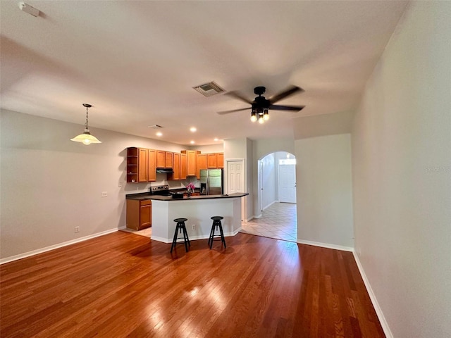 608 Black Lion Dr NE, Saint Petersburg, FL 33716 - kitchen featuring stainless steel appliances, open shelves, arched walkways, dark countertops, and under cabinet range hood