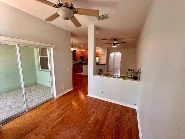 608 Black Lion Dr NE, Saint Petersburg, FL 33716 - unfurnished living room with a ceiling fan, wood finished floors, arched walkways, and baseboards