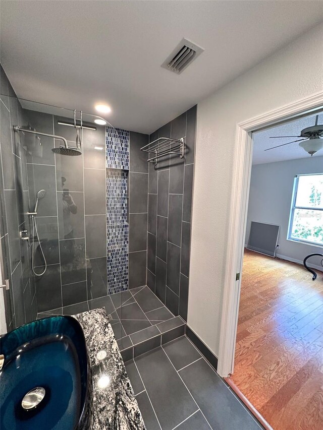 608 Black Lion Dr NE, Saint Petersburg, FL 33716 - bathroom with a tile shower, tile patterned floors, and baseboards