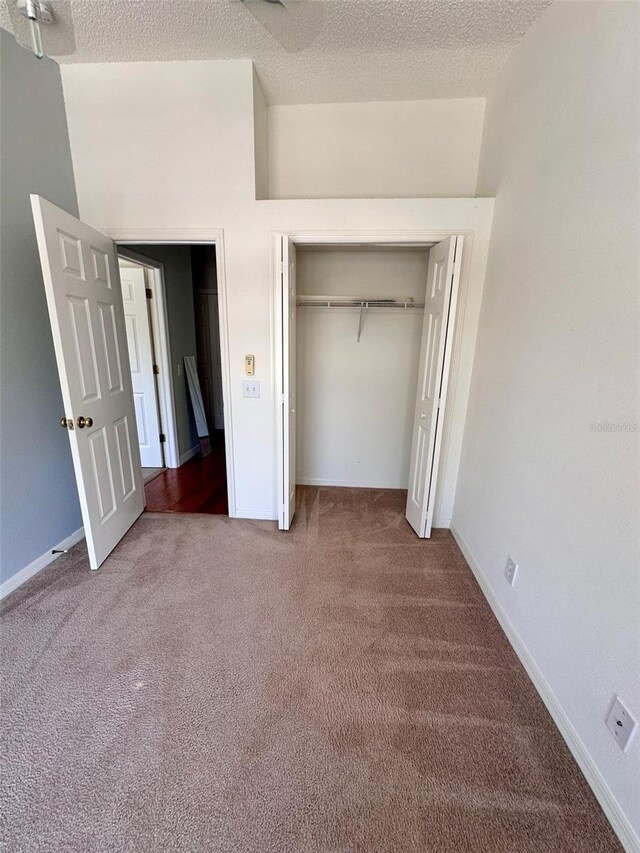 608 Black Lion Dr NE, Saint Petersburg, FL 33716 - unfurnished bedroom featuring carpet flooring, a textured ceiling, a closet, and baseboards