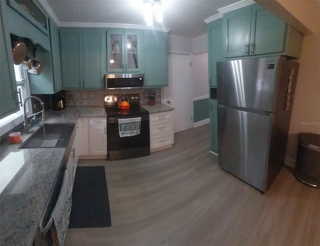 10142 118th Ave, Largo, FL 33773 - kitchen featuring stainless steel appliances, a sink, light wood finished floors, decorative backsplash, and ornamental molding