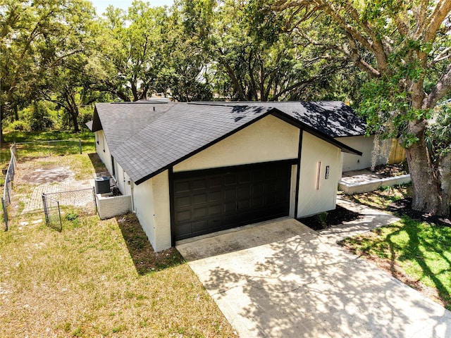 4260 Saint Lawrence Dr, New Port Richey, FL 34655 - view of front facade featuring stucco siding, roof with shingles, central AC, and an attached garage