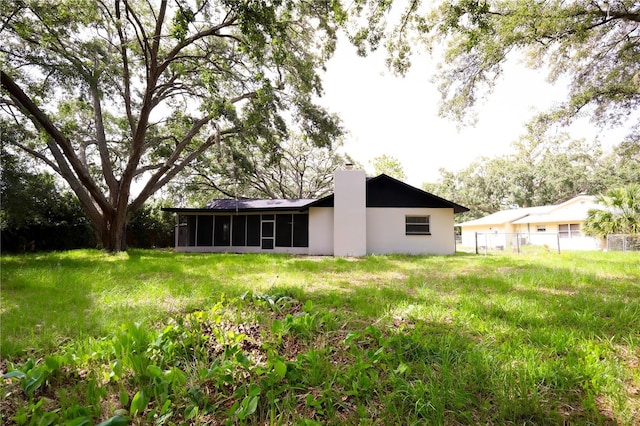 4260 Saint Lawrence Dr, New Port Richey, FL 34655 - back of property with a sunroom, a chimney, and stucco siding