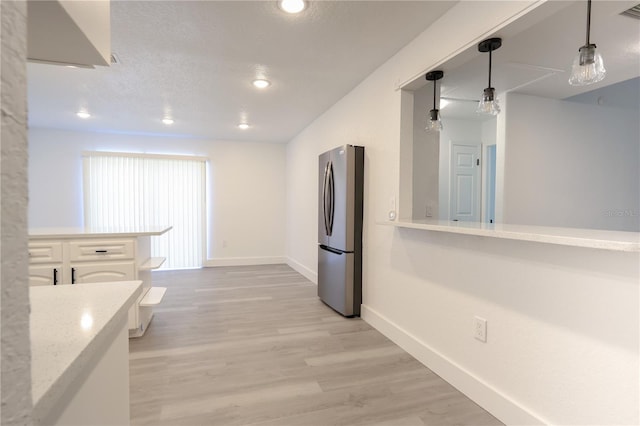 4260 Saint Lawrence Dr, New Port Richey, FL 34655 - kitchen featuring freestanding refrigerator, baseboards, light wood-type flooring, recessed lighting, and hanging light fixtures