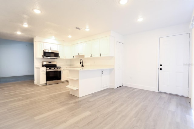 4260 Saint Lawrence Dr, New Port Richey, FL 34655 - kitchen featuring stainless steel appliances, baseboards, white cabinetry, light wood-type flooring, and recessed lighting