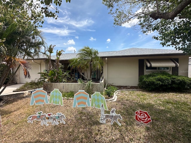 1559 San Roy Dr, Dunedin, FL 34698 - view of front of home featuring stucco siding and an attached garage