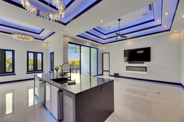 6534 Simone Shores Cir, Apollo Beach, FL 33572 - kitchen with a tray ceiling, a chandelier, a sink, and open floor plan