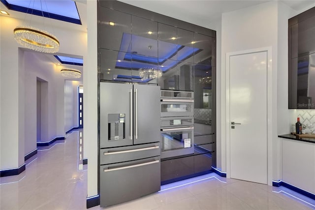6534 Simone Shores Cir, Apollo Beach, FL 33572 - kitchen with appliances with stainless steel finishes, backsplash, light tile patterned flooring, and modern cabinets
