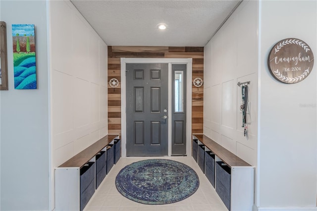 3968 Orchard Hill Cir, Palm Harbor, FL 34684 - mudroom featuring wooden walls, a textured ceiling, and light tile patterned floors