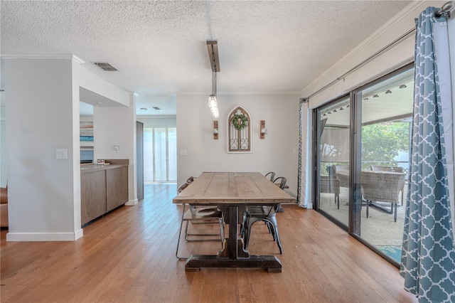 3968 Orchard Hill Cir, Palm Harbor, FL 34684 - dining room featuring light wood-style flooring, a textured ceiling, crown molding, and baseboards