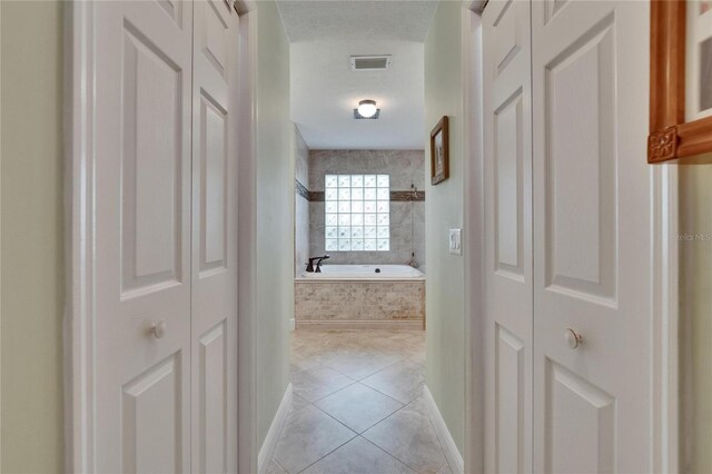 905 Balsamina Dr, Brandon, FL 33510 - hall with light tile patterned flooring, baseboards, and a textured ceiling