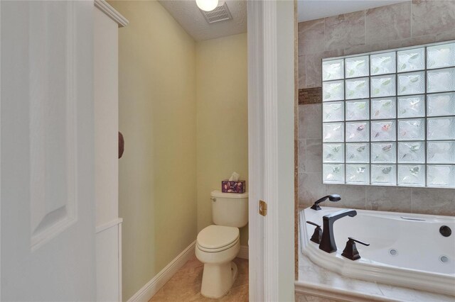 905 Balsamina Dr, Brandon, FL 33510 - bathroom with a tub with jets, toilet, tile patterned flooring, and baseboards
