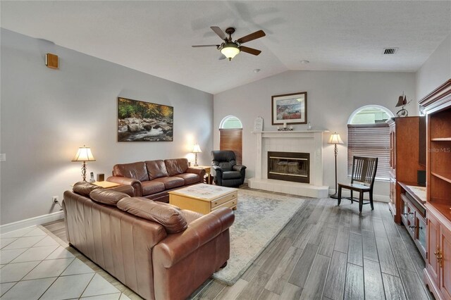 905 Balsamina Dr, Brandon, FL 33510 - living room featuring a ceiling fan, vaulted ceiling, a fireplace, light wood-type flooring, and baseboards