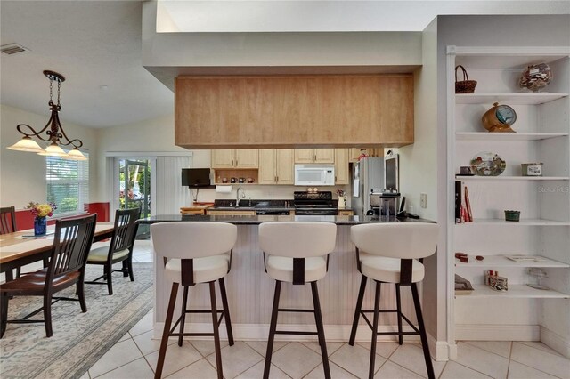 905 Balsamina Dr, Brandon, FL 33510 - kitchen featuring white microwave, electric range oven, dark countertops, a peninsula, and a kitchen breakfast bar