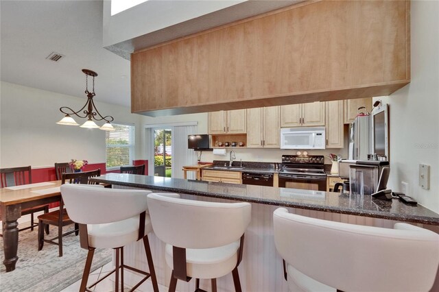 905 Balsamina Dr, Brandon, FL 33510 - kitchen with black appliances, a sink, a kitchen bar, a peninsula, and pendant lighting
