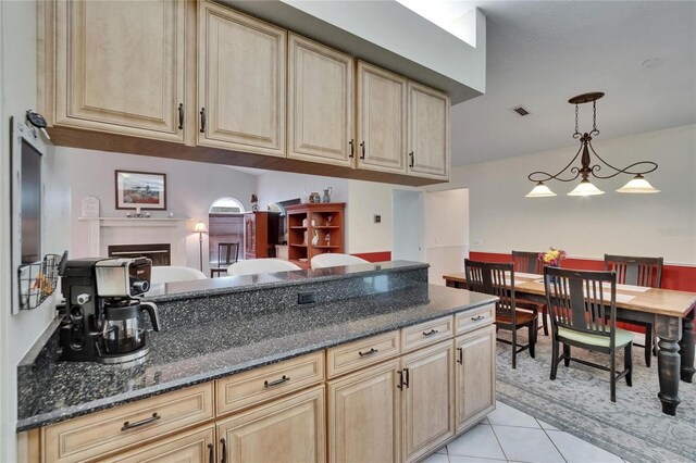 905 Balsamina Dr, Brandon, FL 33510 - kitchen with light tile patterned floors, light brown cabinetry, dark stone countertops, and hanging light fixtures