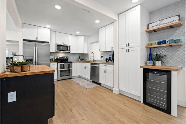 3300 52nd St N, Saint Petersburg, FL 33710 - kitchen featuring butcher block counters, appliances with stainless steel finishes, beverage cooler, a sink, and backsplash