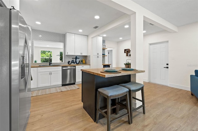 3300 52nd St N, Saint Petersburg, FL 33710 - kitchen with appliances with stainless steel finishes, a sink, butcher block counters, light wood-type flooring, and recessed lighting