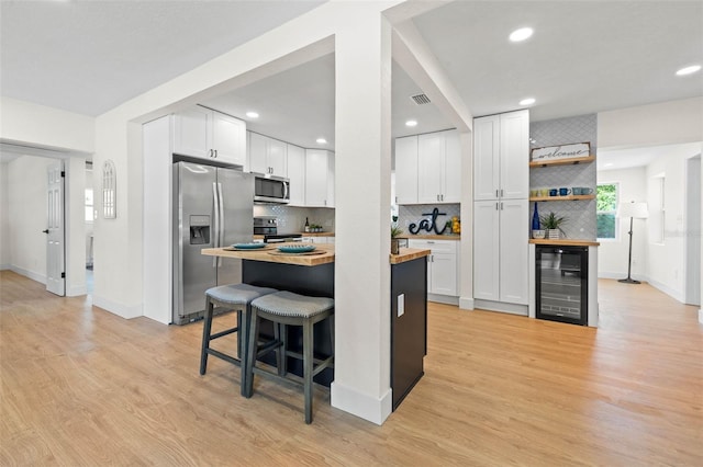 3300 52nd St N, Saint Petersburg, FL 33710 - kitchen with appliances with stainless steel finishes, beverage cooler, tasteful backsplash, white cabinets, and recessed lighting