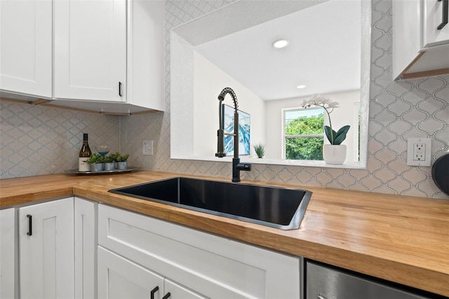 3300 52nd St N, Saint Petersburg, FL 33710 - kitchen featuring butcher block countertops, a sink, white cabinetry, backsplash, and wallpapered walls