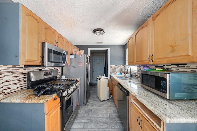 11486 92nd St N, Largo, FL 33773 - kitchen with appliances with stainless steel finishes, a sink, a textured ceiling, and backsplash
