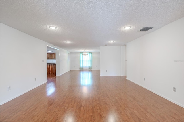 12220 Twin Branch Acres Rd, Tampa, FL 33626 - empty room featuring light wood-style floors, a textured ceiling, baseboards, and recessed lighting