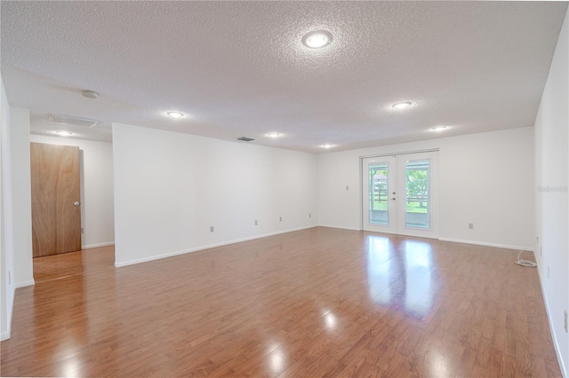 12220 Twin Branch Acres Rd, Tampa, FL 33626 - unfurnished room with a textured ceiling, light wood-type flooring, baseboards, recessed lighting, and french doors