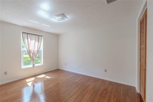 12220 Twin Branch Acres Rd, Tampa, FL 33626 - unfurnished bedroom featuring a textured ceiling, wood finished floors, baseboards, and a closet