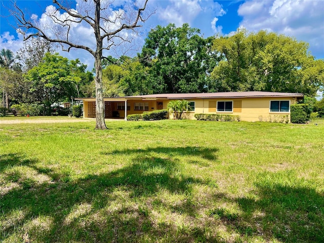 10308 Fore Dr, Tampa, FL 33612 - ranch-style house with a front lawn, driveway, an attached carport, and view of wooded area
