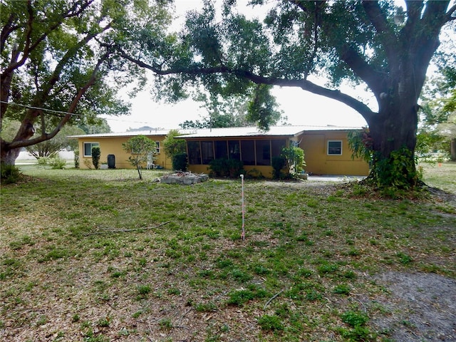 10308 Fore Dr, Tampa, FL 33612 - view of front facade featuring a sunroom and a front yard