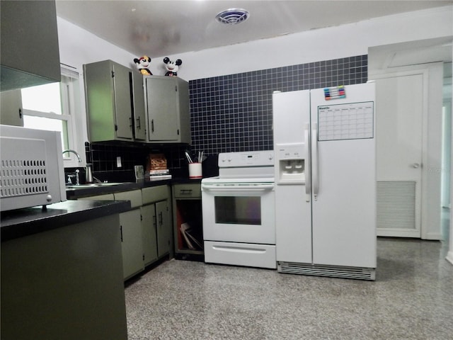 10308 Fore Dr, Tampa, FL 33612 - kitchen with white appliances, dark countertops, decorative backsplash, a sink, and gray cabinetry