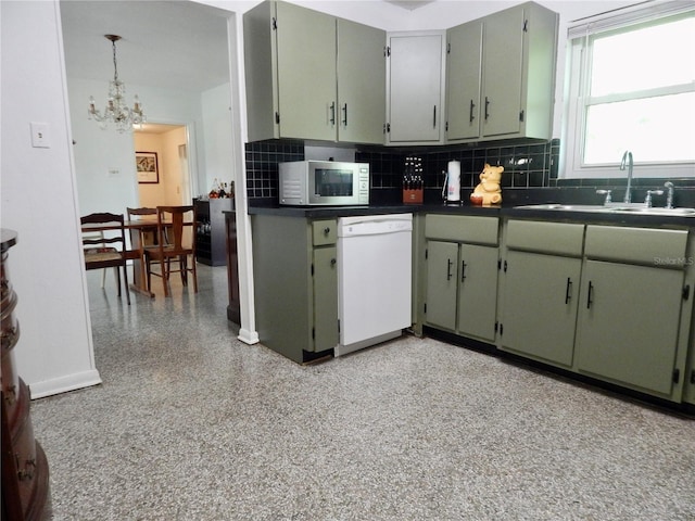 10308 Fore Dr, Tampa, FL 33612 - kitchen with dishwasher, a sink, a chandelier, dark countertops, and backsplash