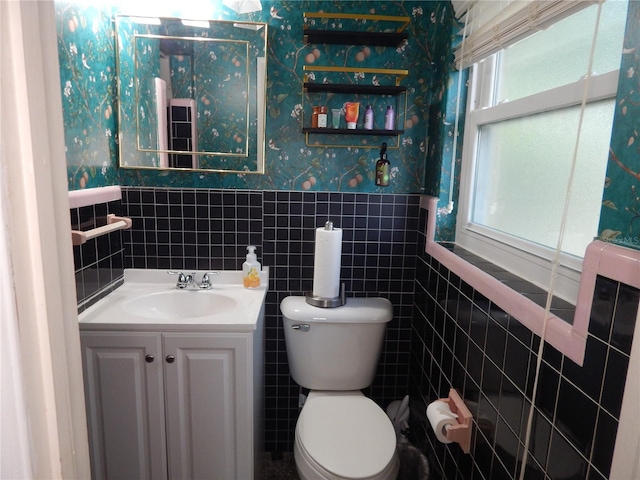 10308 Fore Dr, Tampa, FL 33612 - bathroom featuring wallpapered walls, toilet, tile walls, a wainscoted wall, and vanity