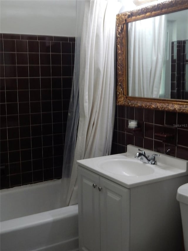10308 Fore Dr, Tampa, FL 33612 - bathroom with vanity, shower / tub combo, tile walls, and toilet