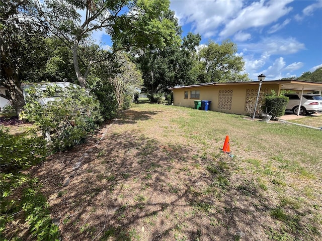 10308 Fore Dr, Tampa, FL 33612 - view of grassy yard with a carport
