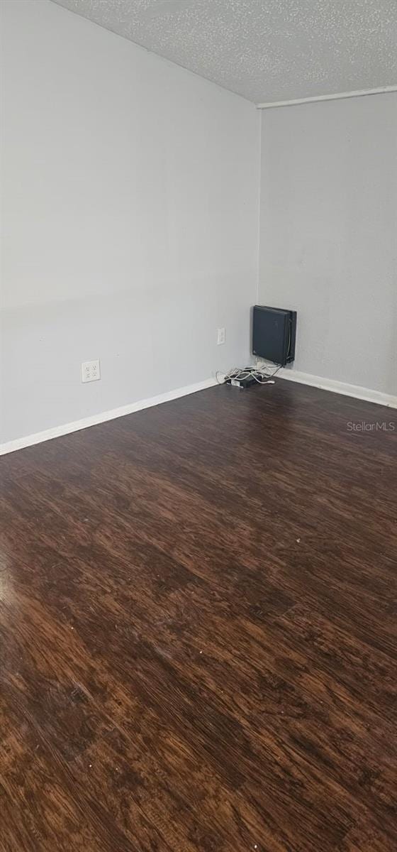 9307 N 16th St, Tampa, FL 33612 - unfurnished living room with a textured ceiling, wood finished floors, and baseboards