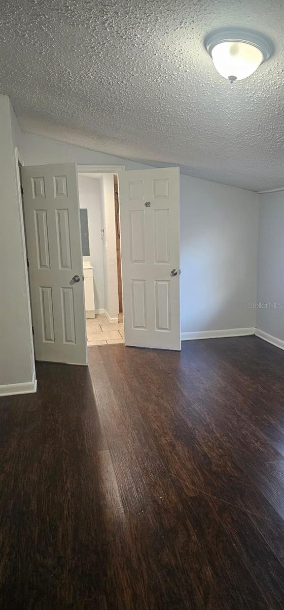 9307 N 16th St, Tampa, FL 33612 - empty room featuring wood finished floors, baseboards, and a textured ceiling