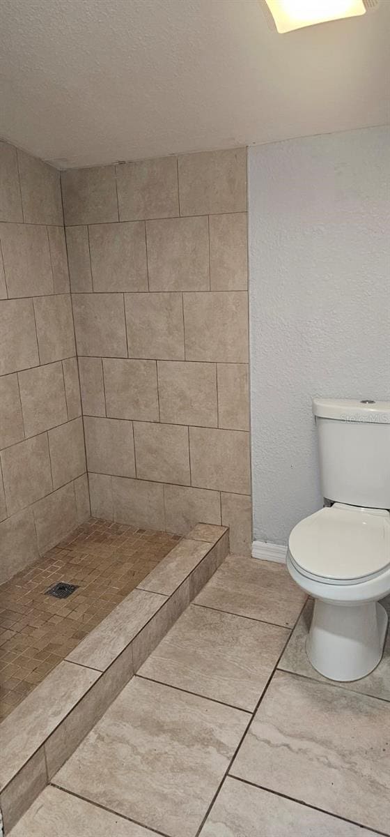 9307 N 16th St, Tampa, FL 33612 - full bath featuring toilet, tiled shower, tile patterned flooring, and baseboards