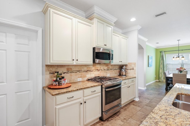 5401 Match Point Pl, Lithia, FL 33547 - kitchen featuring stainless steel appliances, crown molding, arched walkways, tasteful backsplash, and baseboards