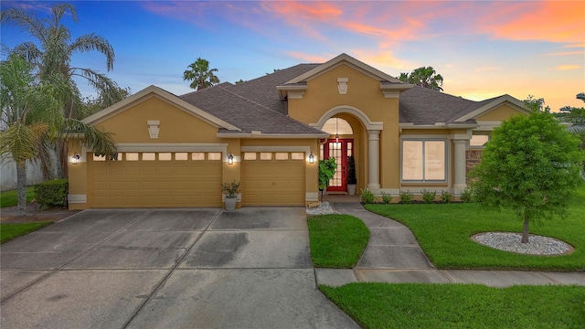 1443 Obear Ct, Wesley Chapel, FL 33543 - traditional home with stucco siding, a garage, a yard, and a shingled roof