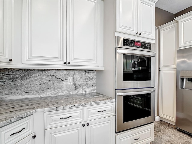 1443 Obear Ct, Wesley Chapel, FL 33543 - kitchen with stainless steel appliances, white cabinets, decorative backsplash, and light stone countertops