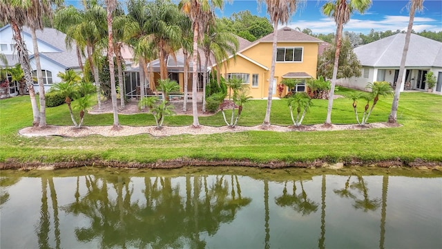 1443 Obear Ct, Wesley Chapel, FL 33543 - rear view of house featuring stucco siding, a water view, and a yard