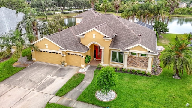 1443 Obear Ct, Wesley Chapel, FL 33543 - view of front of property featuring stucco siding, roof with shingles, a garage, a water view, and a front lawn