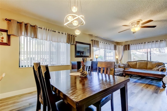 700 Starkey Rd Unit 1216, Largo, FL 33771 - dining area with wood finished floors, baseboards, a ceiling fan, a chandelier, and a textured ceiling