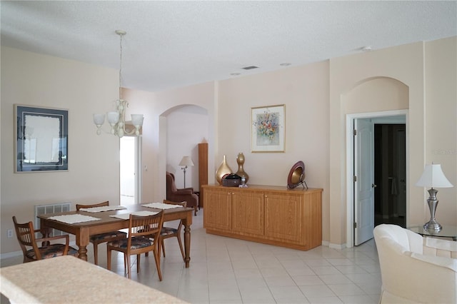 2325 Brookfield Greens Cir Unit 41, Sun City Center, FL 33573 - dining area with arched walkways, a chandelier, light tile patterned floors, and a textured ceiling