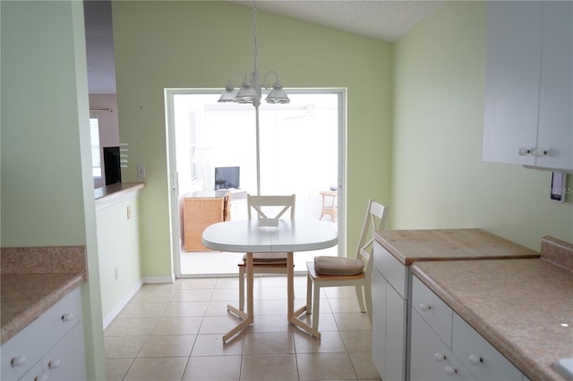 2325 Brookfield Greens Cir Unit 41, Sun City Center, FL 33573 - dining area with lofted ceiling, a chandelier, light tile patterned flooring, and baseboards